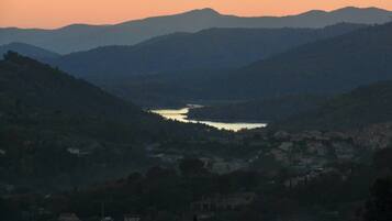 A valley with a river, surrounded by hills and a small town.