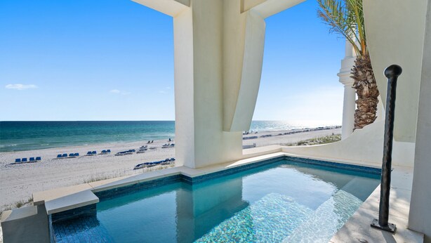 A pool with a view of the beach and ocean.