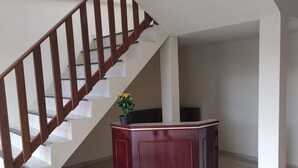 A staircase with wooden railings and a dark wooden cabinet with a potted plant. - Hotel Metropolitano  (Major Vieira)