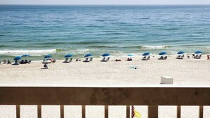 Ein Strand mit Reihen von Sonnenschirmen und Liegestühlen.