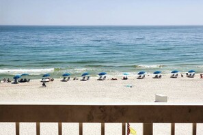 A beach with rows of sun umbrellas and lounge chairs.