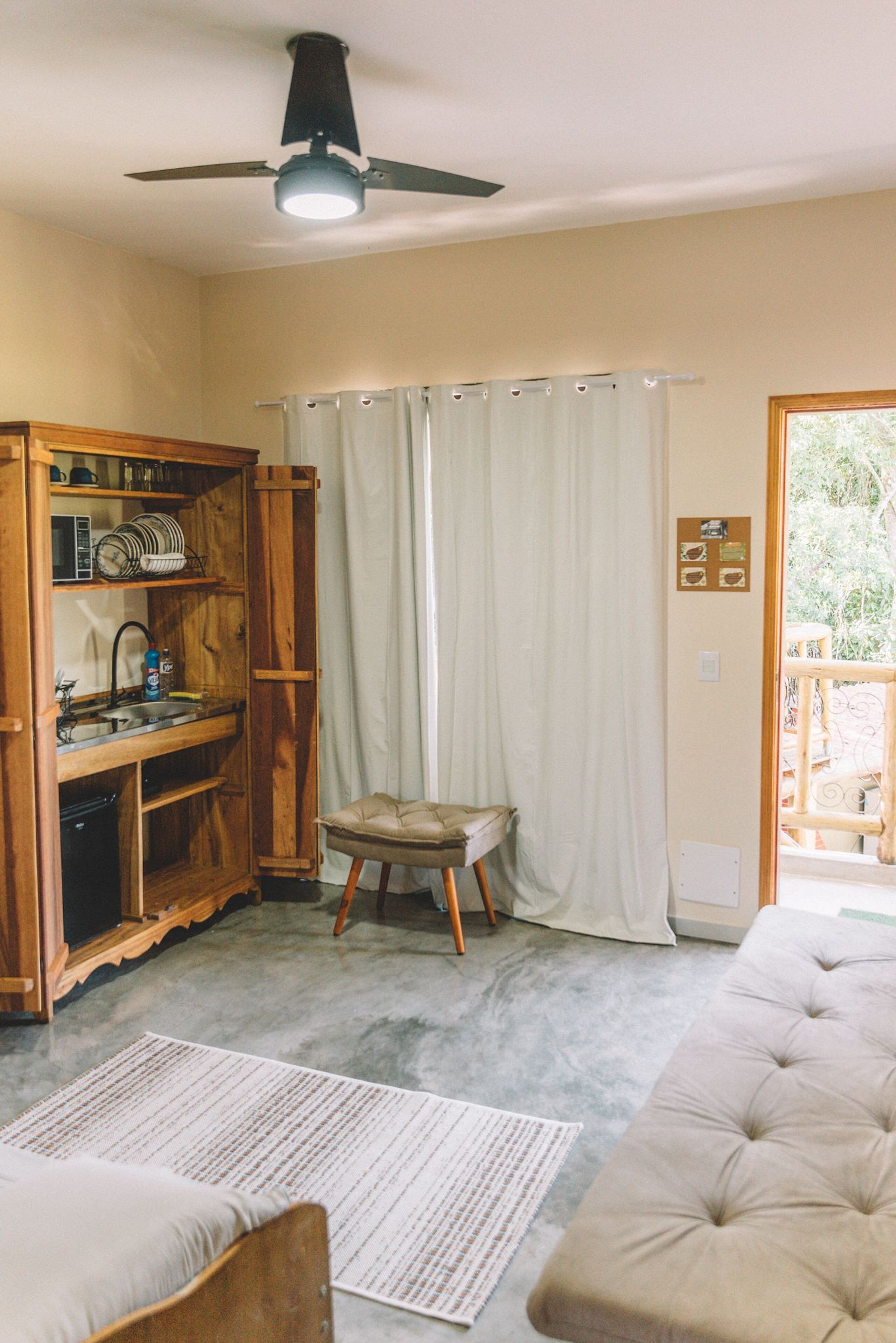 A compact kitchen with wooden cabinets, a built-in sink, and a ceiling fan.