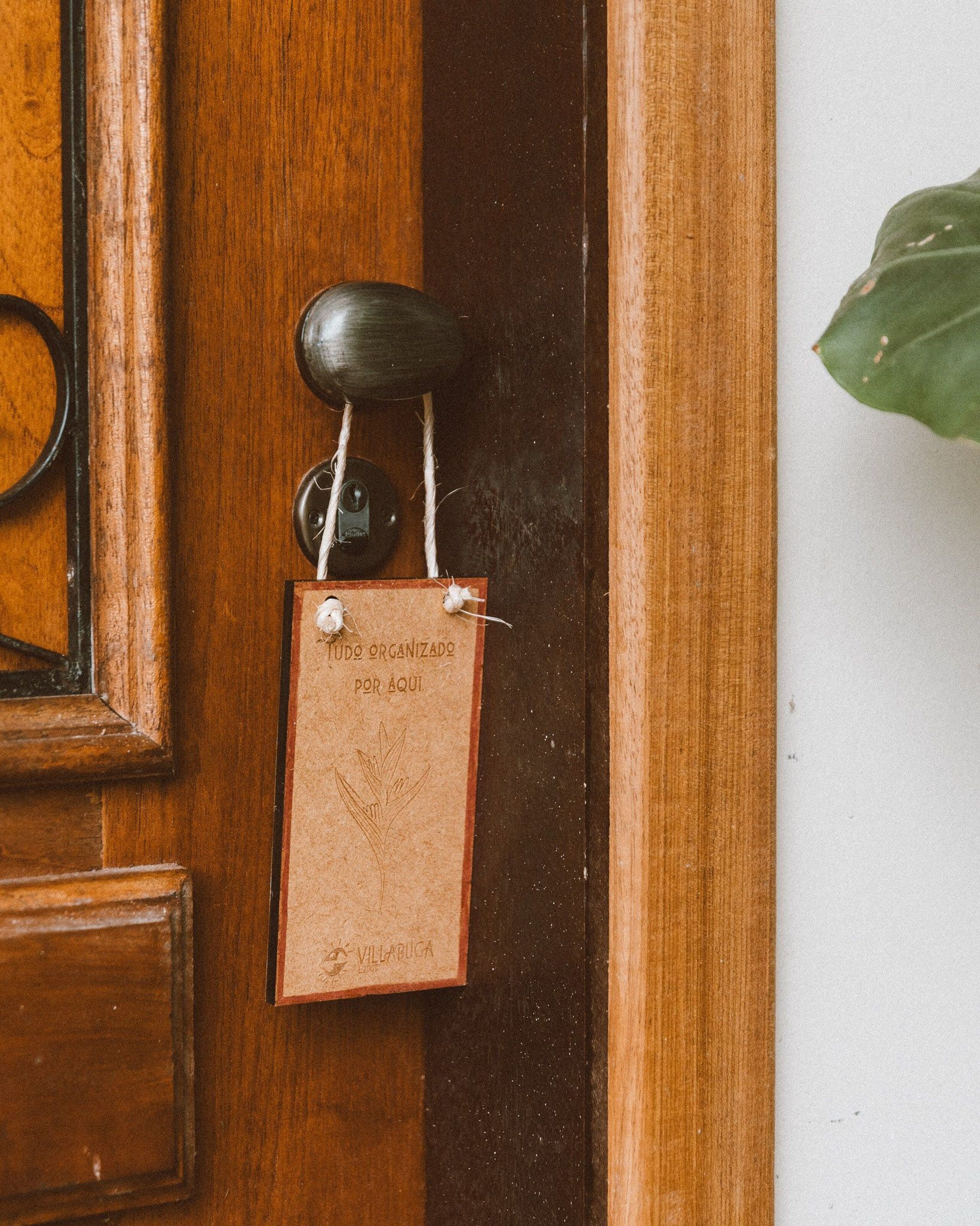Une porte en bois ornée d’une poignée de porte en laiton et d’une petite plaque en laiton fixée sur celle-ci.