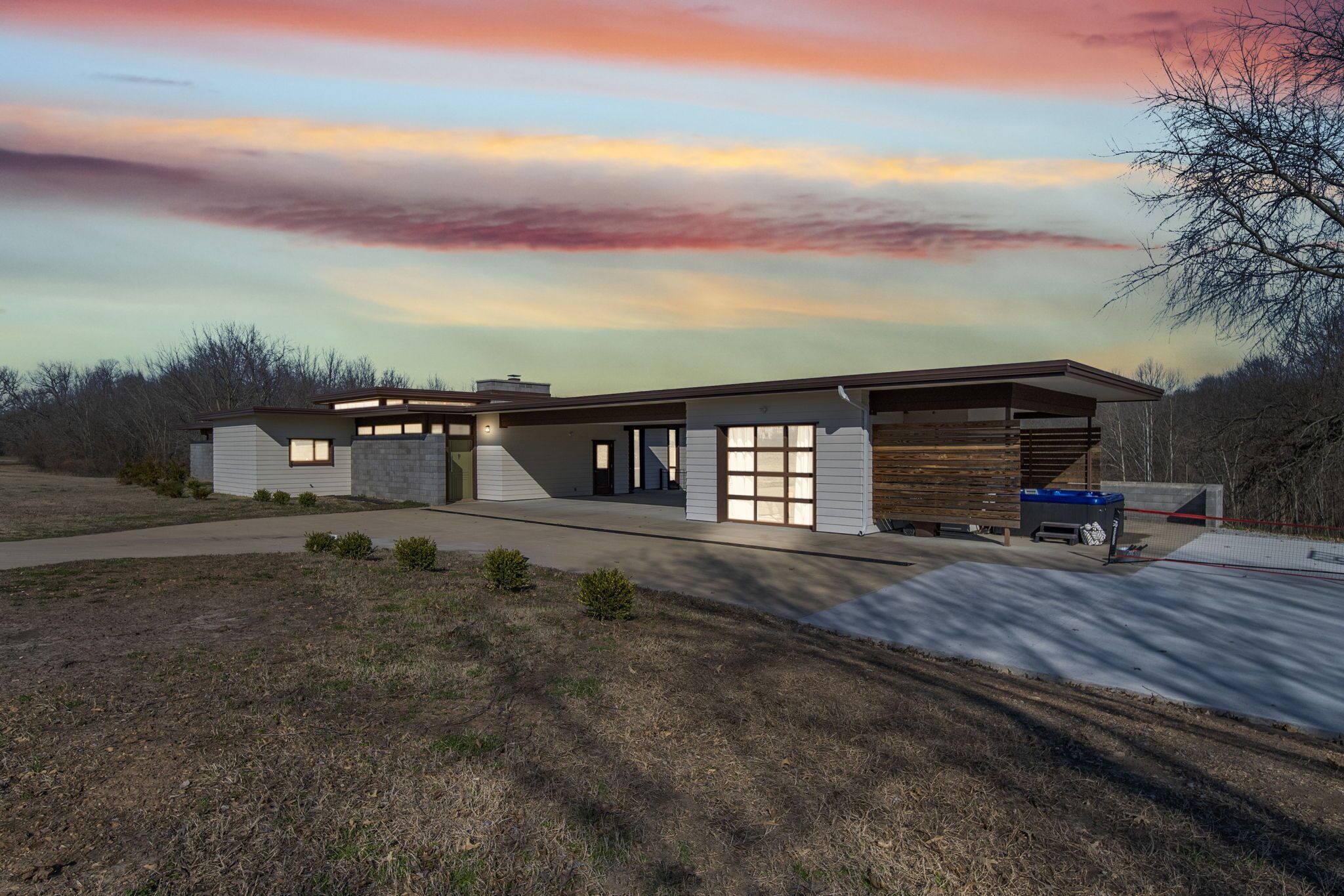 A modern two-story house with a garage, a covered outdoor area, and a driveway.