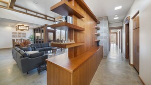 A spacious living area with a wooden coffee table, grey sofas, and a large window. - Corporate*Hot Tub•20 Acres•King Beds•Firepit•Views (Grove)
