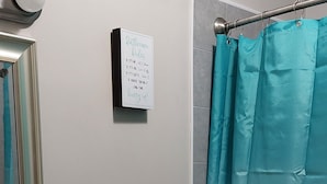 Un baño con inodoro, lavamanos y cortina de ducha azul.