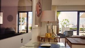 Une chambre d’hôtel équipée d’un bureau, d’un ordinateur, d’une lampe et de grandes fenêtres donnant sur l’extérieur.