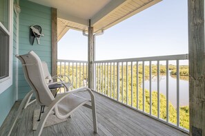 A balcony with a view of a water body and vegetation. - Nature's Landing C302 Pool and Amazing Water View! (Cedar Key)