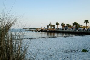 Enjoy a serene beach experience with a picturesque pier and calm waters.