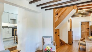 A spacious living area with a wooden staircase, a kitchen in the background, and a dining area with a table and chairs. - 1 bedroom accommodation in Poundsgate, near Newton Abbot (Poundsgate, near Newton Abbot)