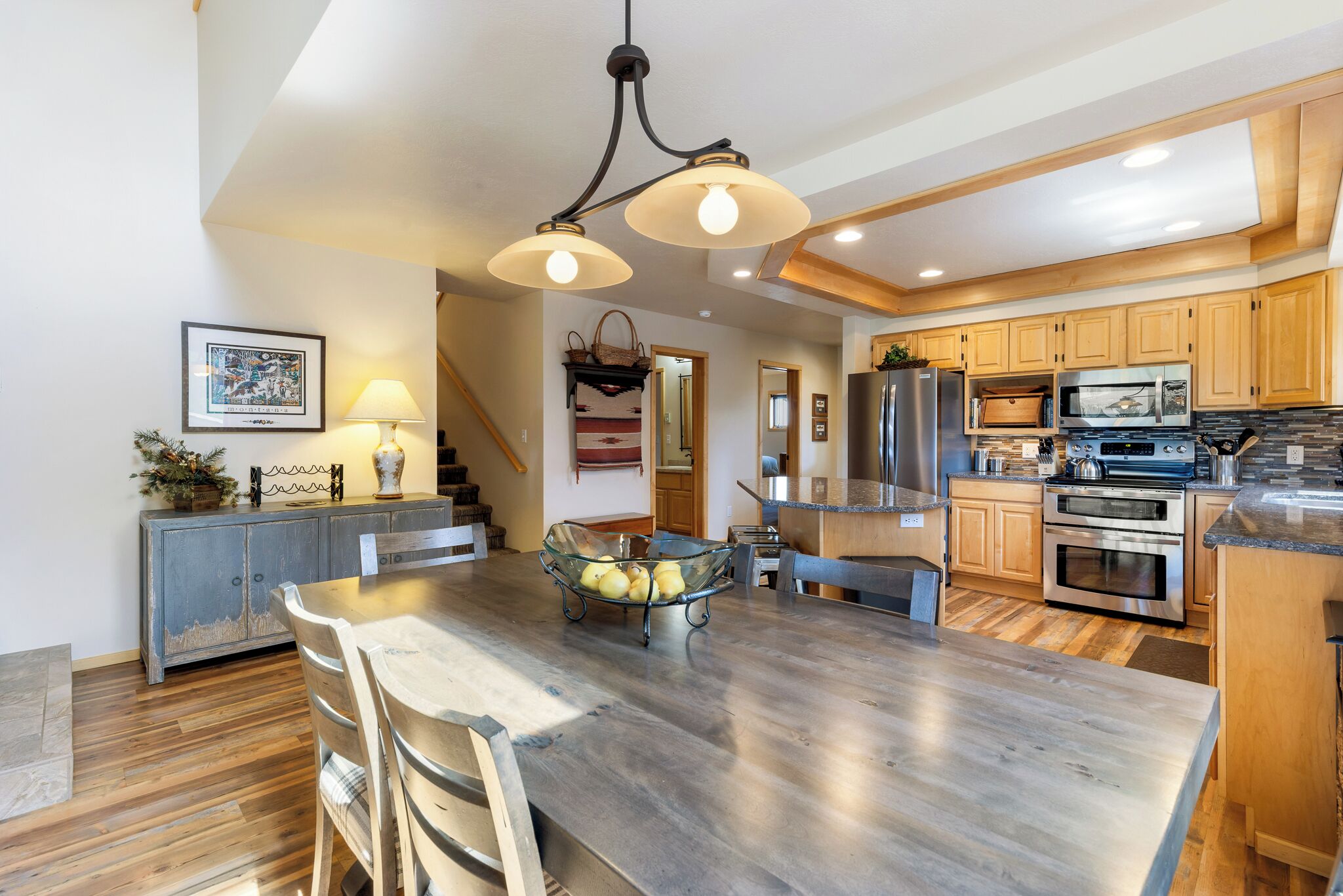 Cocina amplia con armarios de madera, una isla central y electrodomésticos modernos.