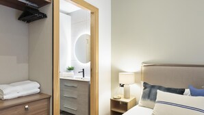 Une chambre d’hôtel avec un lit, une table de chevet, une lampe et une vue sur la salle de bain.