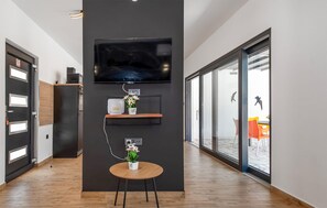 Enjoy a cozy space with a flat-screen TV, small table for two, and a potted plant.