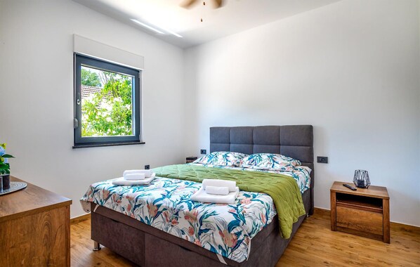 A bedroom with a bed, a window, a bedside table, and a nightstand. - Nice home in Trbounje with WiFi (Trbounje)