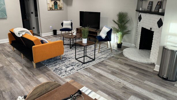 Un salon moderne avec un canapé, une table basse, un téléviseur et une cheminée.