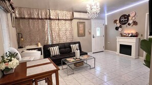 Una sala de estar con sofá, mesa de centro y chimenea.