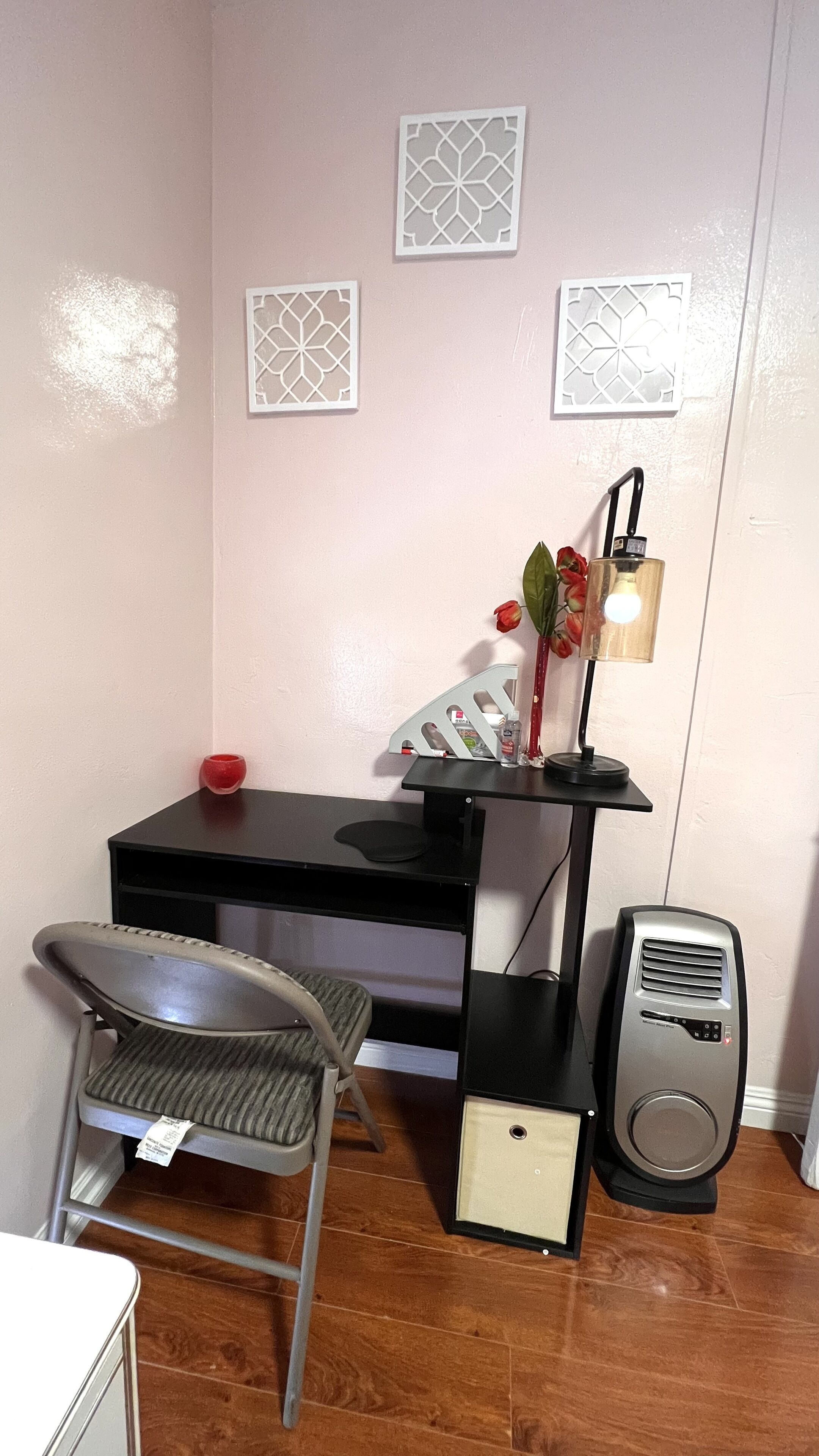 Un petit bureau comprenant un bureau, une chaise, une lampe et un haut-parleur.
