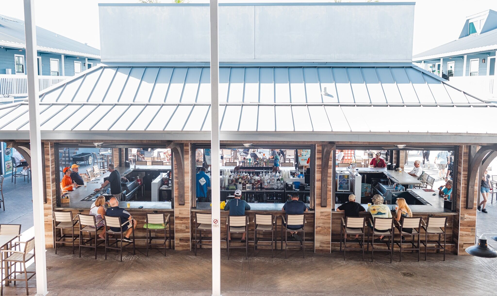 An outdoor bar area with multiple seating arrangements and a bar counter.
