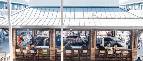 An outdoor bar area with multiple seating arrangements and a bar counter.