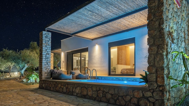 A modern house with a stone exterior, a swimming pool, and a covered patio area. - Casatino Villas #1 (kalianeika)