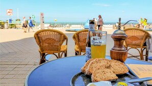 Et bord med en flaske Blanche de Narbonne, et glas øl og skiver af brød.