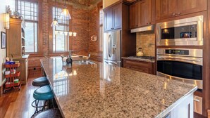 A kitchen with granite countertops, stainless steel appliances, and wooden cabinets. - Beautiful 3 Bedroom l Sleeps 5 (Fernie)