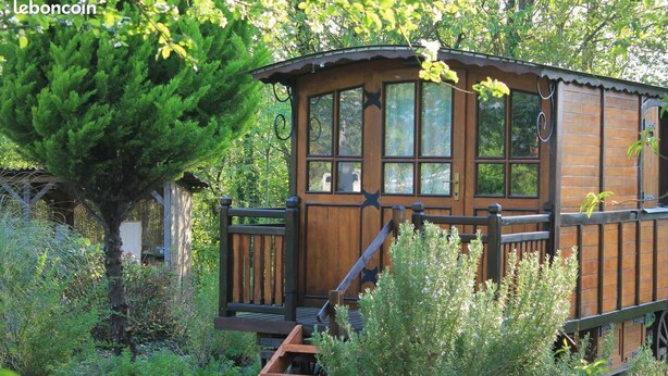Een houten chalet met een houten terras en een trap naar de ingang.