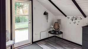 A room with a large glass door leading to a garden, a small table with a vase, and decorative wall stickers. - Stunning home in Rødby with kitchen (Rødby)