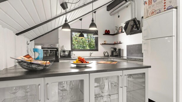 A modern kitchen with a central island, built-in appliances, and pendant lighting. - Stunning home in Rødby with kitchen (Rødby)