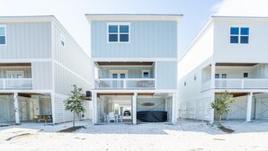 A three-story beachfront building with balconies and covered outdoor seating areas. - Sun-Kissed at Summer Salt (Orange Beach)
