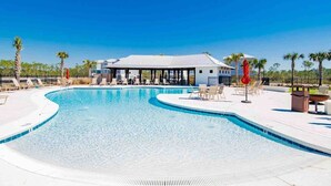 A swimming pool with lounge chairs and a covered seating area. - Sun-Kissed at Summer Salt (Orange Beach)