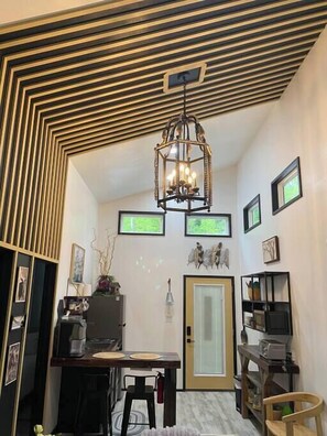 Cozy retreat with a unique geometric ceiling, dining area, kitchenette, and seating space.