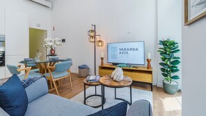 Una sala de estar moderna con sofá, mesa de comedor y televisor.