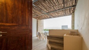 A modern interior with a wooden door, a staircase, and a dining area with chairs and a table. - Fantastic Apartment with Private Pool · 305 (Tulum)