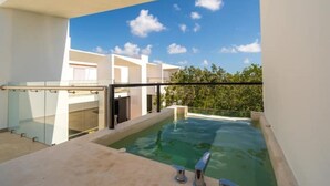 Et moderne poolområde med krystalklar blå himmel og grøn bevoksning i baggrunden.