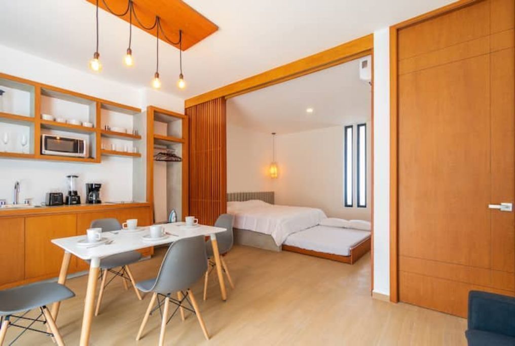 Pieni hotellihuone, jossa on minikeittiö, ruokailutila ja sänky.