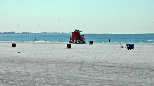 Ein Strand mit einem Rettungsturm, Sand und dem Meer.