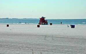 A beach with a lifeguard tower, sand, and the ocean. - Condo# 318 2 Bed/1 bath Condo Steps to Siesta Key Beach! (Sarasota)