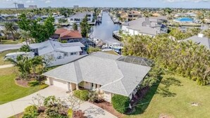 A residential area with houses, a canal, and a swimming pool. - Palm Paradise Poolside (Cape Coral)