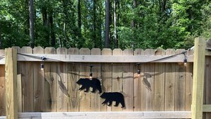A wooden fence with two bear silhouettes. - Unique Tiny Home Escape! Fully Equipped & Relaxing, Privacy-Fenced Outdoor Space (Raleigh)