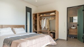 Ein Schlafzimmer mit Bett, Kleiderschrank und Bad.