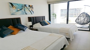 Een hotelkamer met twee bedden, een groot raam en uitzicht op de stad.