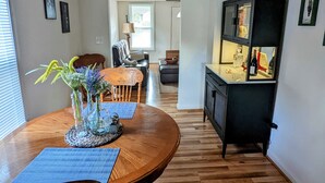 Ein Essbereich mit Holztisch und -stühlen, einer Vitrine und einem zur Wohnzimmer führenden Gang.