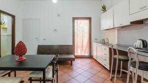 Una cocina compacta con comedor, un sofá y una pequeña zona de bar.