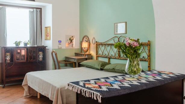 Un dormitorio con cama, mesita de noche, cómoda y ventana.