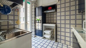 A compact kitchen with a sink, stove, and storage cabinets.