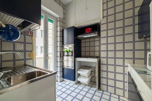A compact kitchen with a sink, stove, and storage cabinets.