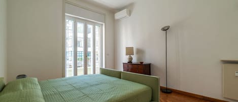 Un dormitorio con cama, cómoda, lámpara y lámpara de pie.