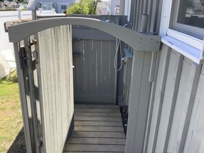 A wooden gate leading to a covered outdoor area with a window on the right. - Spacious Cottage (Mattapoisett)
