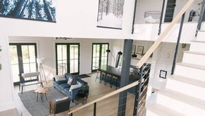 A spacious living area with a sofa, dining table, and staircase. - Sister Bay Eclectic Cottage (Sister Bay)